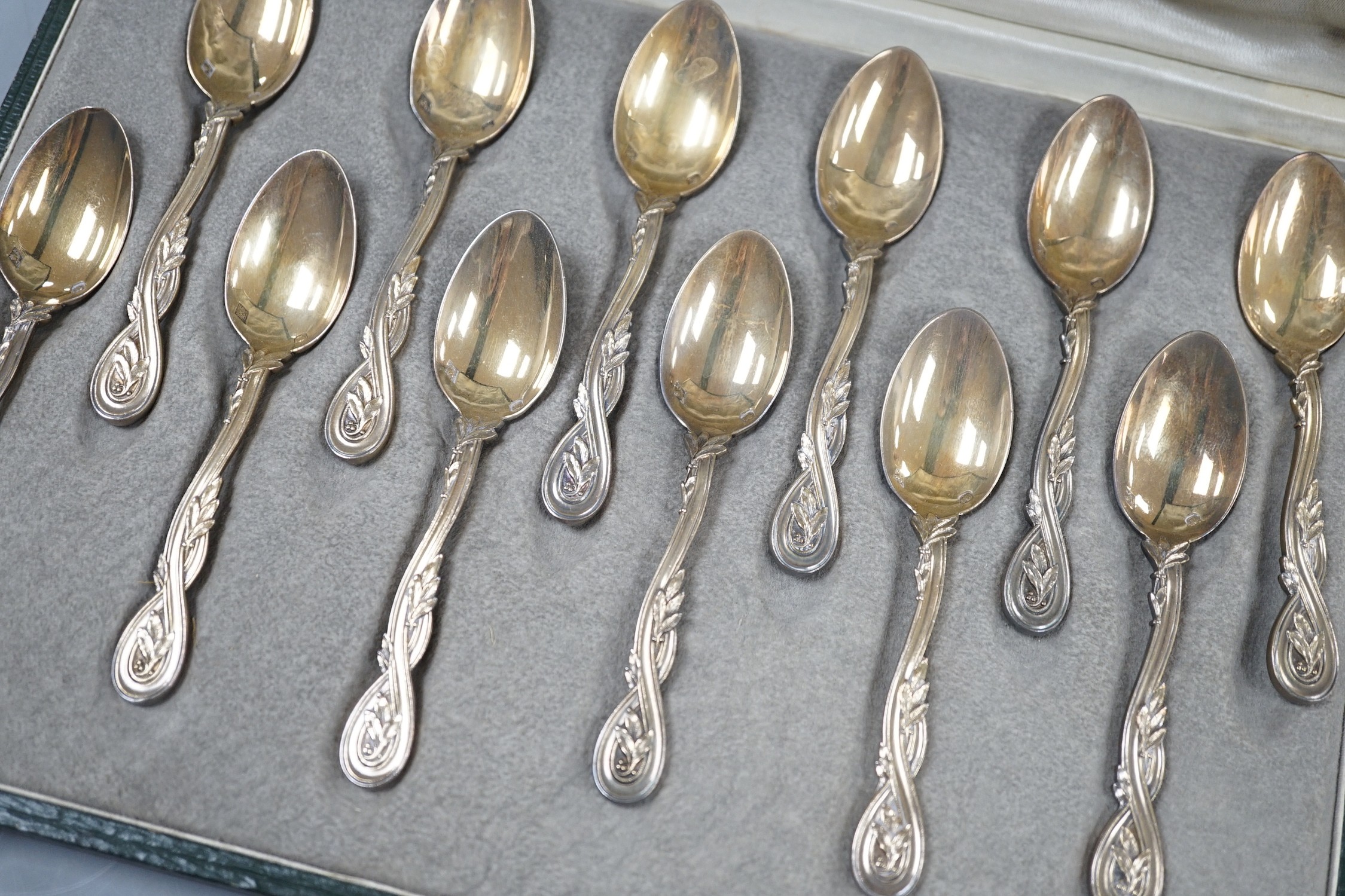 A cased set of twelve early 20th century French 950 standard white metal teaspoons, with foliate scroll terminals, by H. Freres & Co, 99mm.